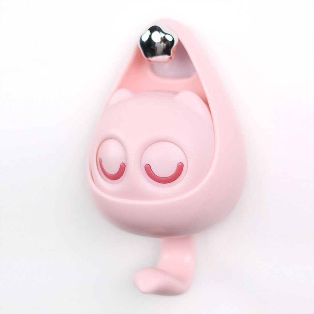 Pink cartoon-style dog tag with a silver bell on a white background